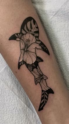 a black and white photo of a fish with flowers on it's side arm