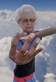 an old woman holding up a large object in the air with clouds and blue sky behind her