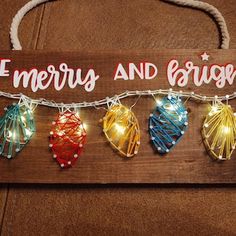 a wooden sign that says merry and bright with string lights hanging from it's sides