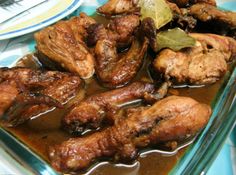 chicken wings are cooked in brown sauce with green leaves