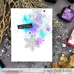 a snowflake card surrounded by glitter and other crafting supplies