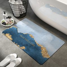 a bathroom rug with a blue and gold design on the floor next to a bathtub