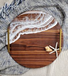 a wooden cutting board topped with food on top of a bed next to a starfish