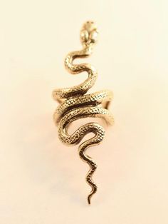 This Snake Ear Cuff is cast in solid 14K gold. The graceful snake wraps playfully along the edge of the ear. It can be worn on either the left or the right ear. (Diamond not included.)Our ear cuffs require no piercings. Starting near the top of the ear, slide the ear cuff down along the edge of the ear's cartilage. You may gently open or close the opening of the ear cuff to accommodate the thickness of your ear.This item usually ships the same or next business day.All Marty Magic Jewelry is pack Bronze Snake Shape Jewelry As Gift, Bronze Snake-shaped Jewelry Gift, Bronze Snake-shaped Jewelry For Gift, Symbolic Snake-shaped Brass Jewelry, Unique Brass Snake Jewelry, Nickel-free Gold Snake Jewelry, Adjustable Brass Snake-shaped Jewelry, Earring Snake, Snake Ear Cuff