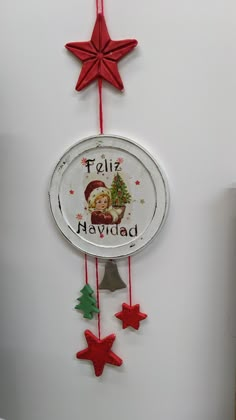 a clock hanging from the side of a white wall next to christmas trees and stars