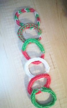 four different colored bracelets sitting on top of a wooden table