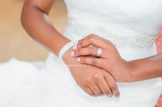 a woman in a wedding dress holding her hands together