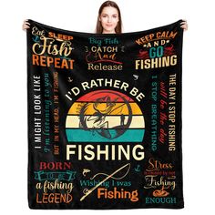 a woman holding up a black blanket with fishing related items on it and the words i'd rather be fishing