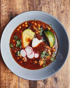 a white bowl filled with soup on top of a wooden table