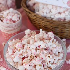 a bowl full of popcorn sitting on top of a red and white striped table cloth