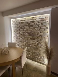 a dining room table and chairs with a brick wall in the background