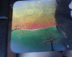 a painted coaster with trees on it