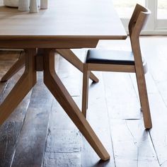 a wooden table with two black chairs next to it