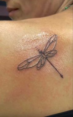 a woman with a dragonfly tattoo on her back