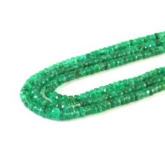 a strand of green glass beads on a white background