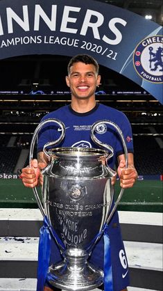 a man holding a soccer trophy in front of him