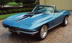 a blue car parked in front of a garage