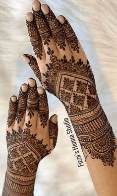 two hands with henna tattoos on them