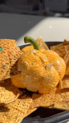 an orange sitting on top of chips in a bowl