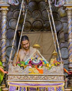 a man sitting in front of a decorated shrine