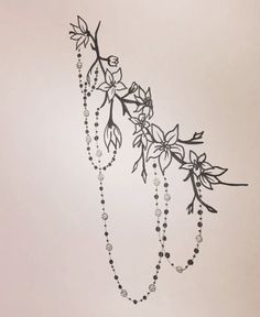 a black and white drawing of a branch with beads hanging from it's end