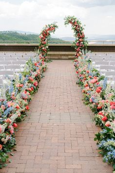 an outdoor ceremony with rows of chairs and flowers