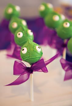 green cake pops with googly eyes and purple bows