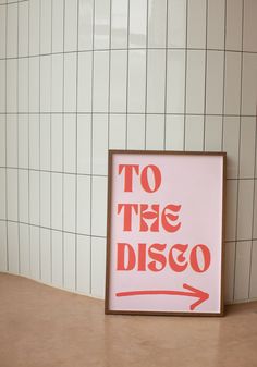 a sign that says to the disco on it in front of a wall with white tiles