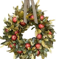 a wreath with apples and leaves on it