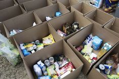 several cardboard boxes filled with different types of food and drink items sitting on the ground