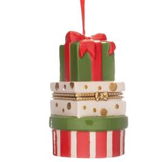 a stack of stacked christmas gifts with red and green ribbons on them, all wrapped in gold foil