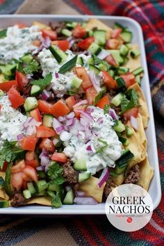 a tray filled with nachos and vegetables on top of a blanket