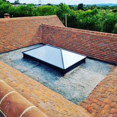 a flat roof with a skylight on top of it in the middle of a brick building