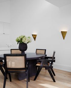 a dining room table with chairs and a vase on it