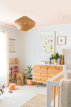 a baby's room with a crib, dresser and pictures on the wall