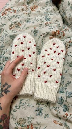 a person laying in bed with two mittens on their hands