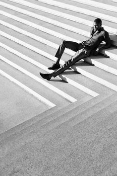 a man sitting on the ground with his legs crossed and feet up in the air