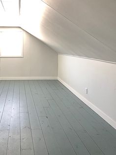 an empty room with white walls and wooden floors