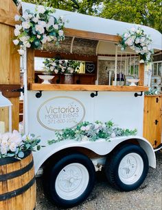 a food truck is decorated with flowers and greenery