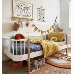 a child's room with a bed, rugs and pictures on the wall