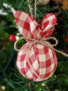 a red and white ornament hanging from a christmas tree