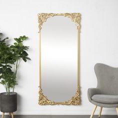 a large mirror sitting next to a chair and potted plant