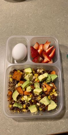 a plastic container filled with rice, fruit and veggies next to an egg