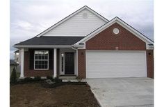 a brick house with white trim and black shutters on the front door is shown