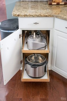 an open cabinet with two pots and pans in it