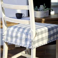 a wooden chair with a checkered seat cover on it's armrests