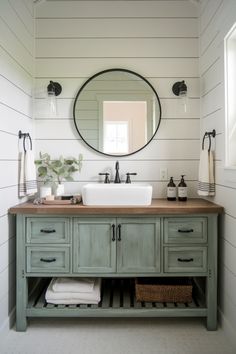 a bathroom with two sinks and a large round mirror above the sink is decorated in white shiping