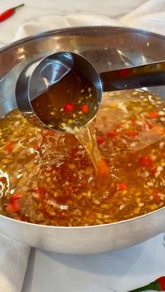 a pot filled with soup sitting on top of a table next to a white cloth