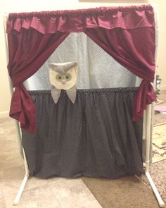 an owl themed baby crib with red curtains and a cat head on the curtain