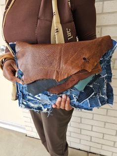 a person is holding a piece of cloth and a tie in their hands while standing against a brick wall